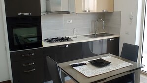 A modern kitchen with a gas stove, oven, and stainless steel cabinets. - Apartment 'Casa Dell'Oleandro' with Private Terrace, Wi-Fi and Air Conditioning (Olbia)