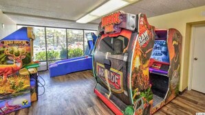 A room with arcade games including 'Jurassic Park' and 'Raw Thrills'. - Cozy 1-bedroom condo in tranquil Myrtle Beach (Myrtle Beach)