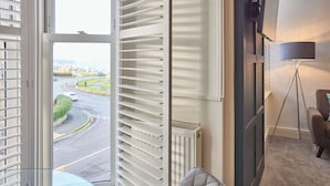 Camera d'albergo con vista su una rotonda, un termosifone, una lampada e una sedia.
