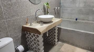 Un baño con inodoro, lavabo, espejo y bañera.
