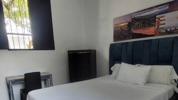 Ein Schlafzimmer mit einem Bett, einem Schreibtisch, einem Stuhl, einer Klimaanlage und einem Poster an der Wand.