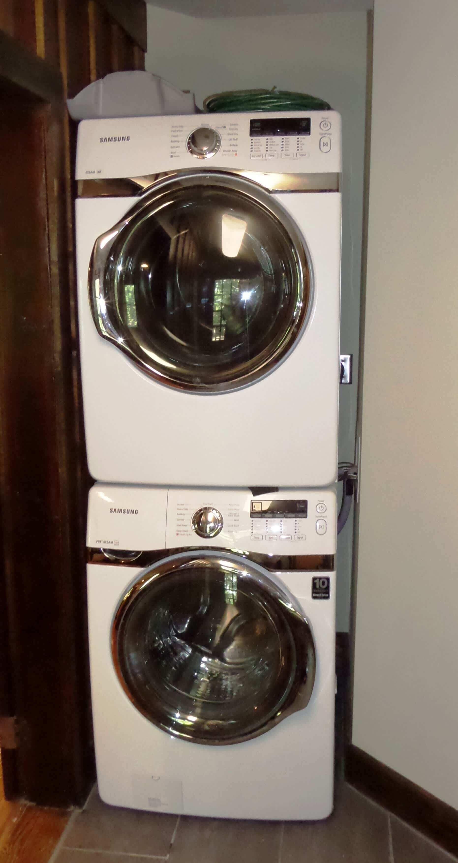 Une machine à laver et un sèche-linge Samsung à chargement frontal, superposés dans une buanderie.
