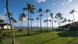A well-maintained golf course with a clear view of the ocean and palm trees. - 2 Story Ocean-View 2BR, 2 Lanais, Vaulted Ceilings, Resort Pool -Unit 23 (Koloa)