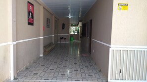 A corridor with patterned flooring, a ceiling light, and a door at the end.