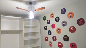 A room with a ceiling fan, a white shelving unit, and a wall decorated with various Funko Pop! figures. - Spacious house with a heated hot tub and pool on Shangri-La Beach. (Pontal do Paraná)