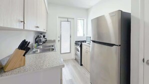 A modern kitchen with stainless steel appliances, a knife block, and a window. - 1BR Miami Beach Apt w/ King + 2 Queens & Smart TV (Miami Beach)
