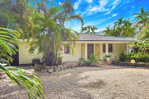 A house with a tiled roof, surrounded by palm trees and a gravel driveway. - Casa in Tropic Paradise with Pool and BBQ (Biscayne Park)
