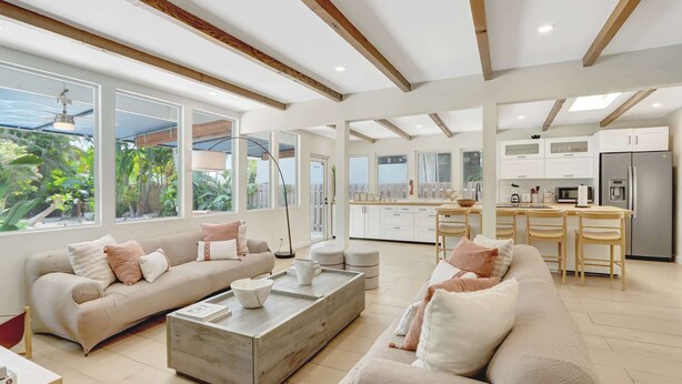 A spacious living area with a sofa, coffee table, and a kitchen in the background. - Casa in Tropic Paradise with Pool and BBQ (Biscayne Park)