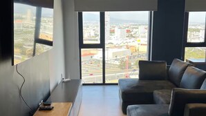 A modern living room with a large TV, a sofa, and a coffee table. - Loft 1 Boudica, Puebla (San Bernardino Tlaxcalancingo)