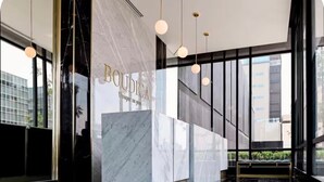 A modern lobby with a marble reception desk, large windows, and hanging pendant lights. - Loft 1 Boudica, Puebla (San Bernardino Tlaxcalancingo)