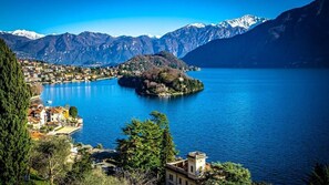 A lake surrounded by mountains and a town with buildings near the water's edge. - Casa Ortensia Blu (Maslianico)