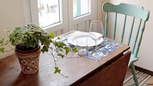 Una mesa de comedor con planta en maceta, un vaso y un plato para dos.