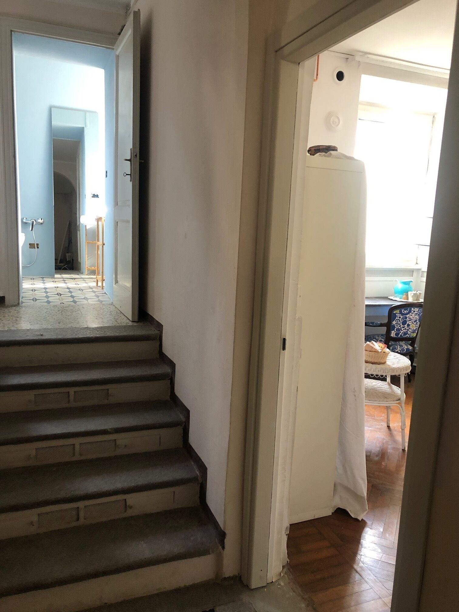 Una escalera que lleva a un cuarto con vista a un balcón.