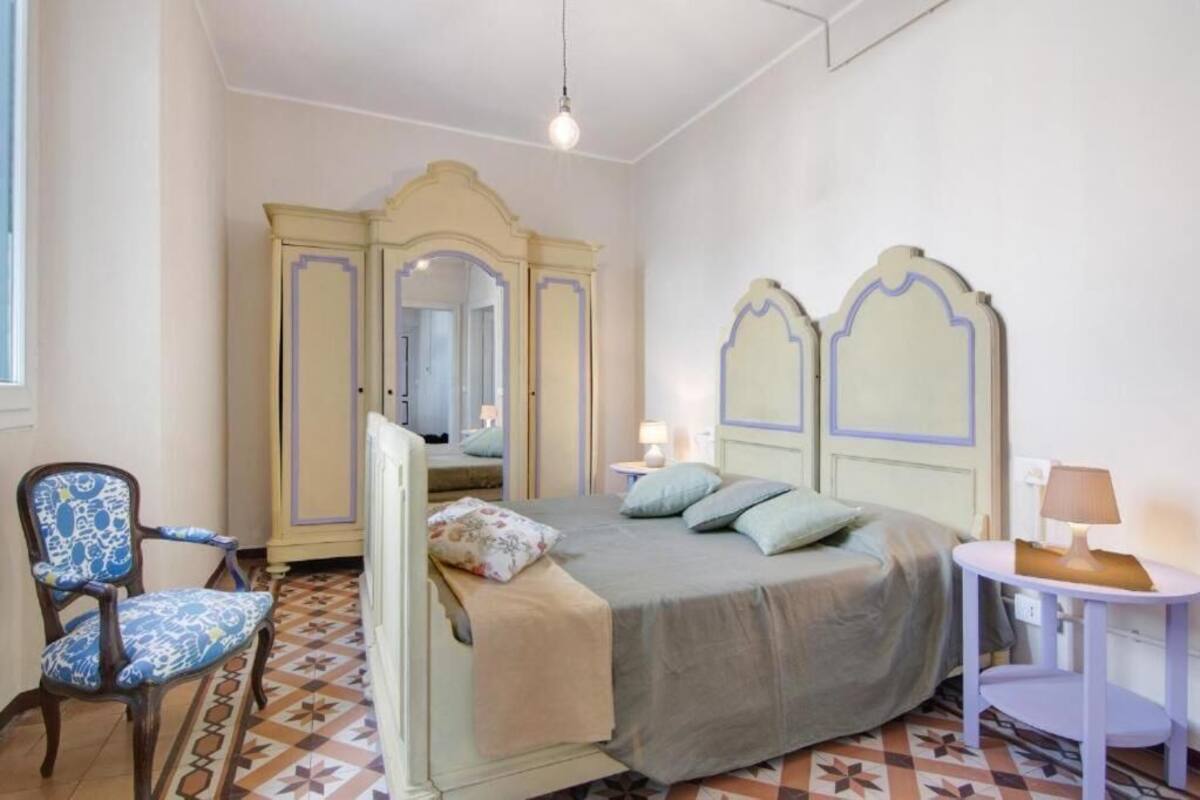 Un dormitorio con cama, una silla, mesita de noche y armario.