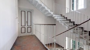 Una escalera con barandas blancas y pasamanos de madera que conduce a un piso superior.