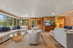 A modern living room with a sofa set, a glass coffee table, and a television. - Lakefront Brainerd Cabin w Deck, Fire Pit! (Brainerd)
