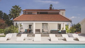 A two-story house with a swimming pool, white lounge chairs, and a patio with outdoor furniture. - Villa delle Sterlizie by LeDhome (Balestrate)
