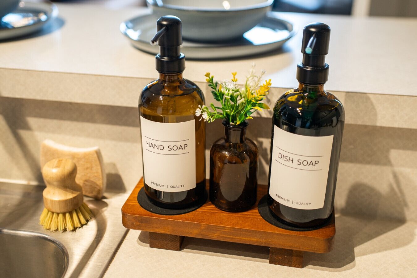 Two bottles of hand and dish soap on a wooden tray.