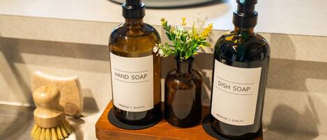 Two bottles of hand and dish soap on a wooden tray.