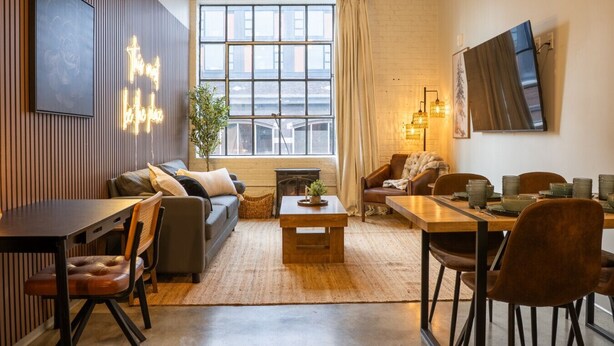 Una sala de estar moderna con sofá, mesa de centro y comedor.