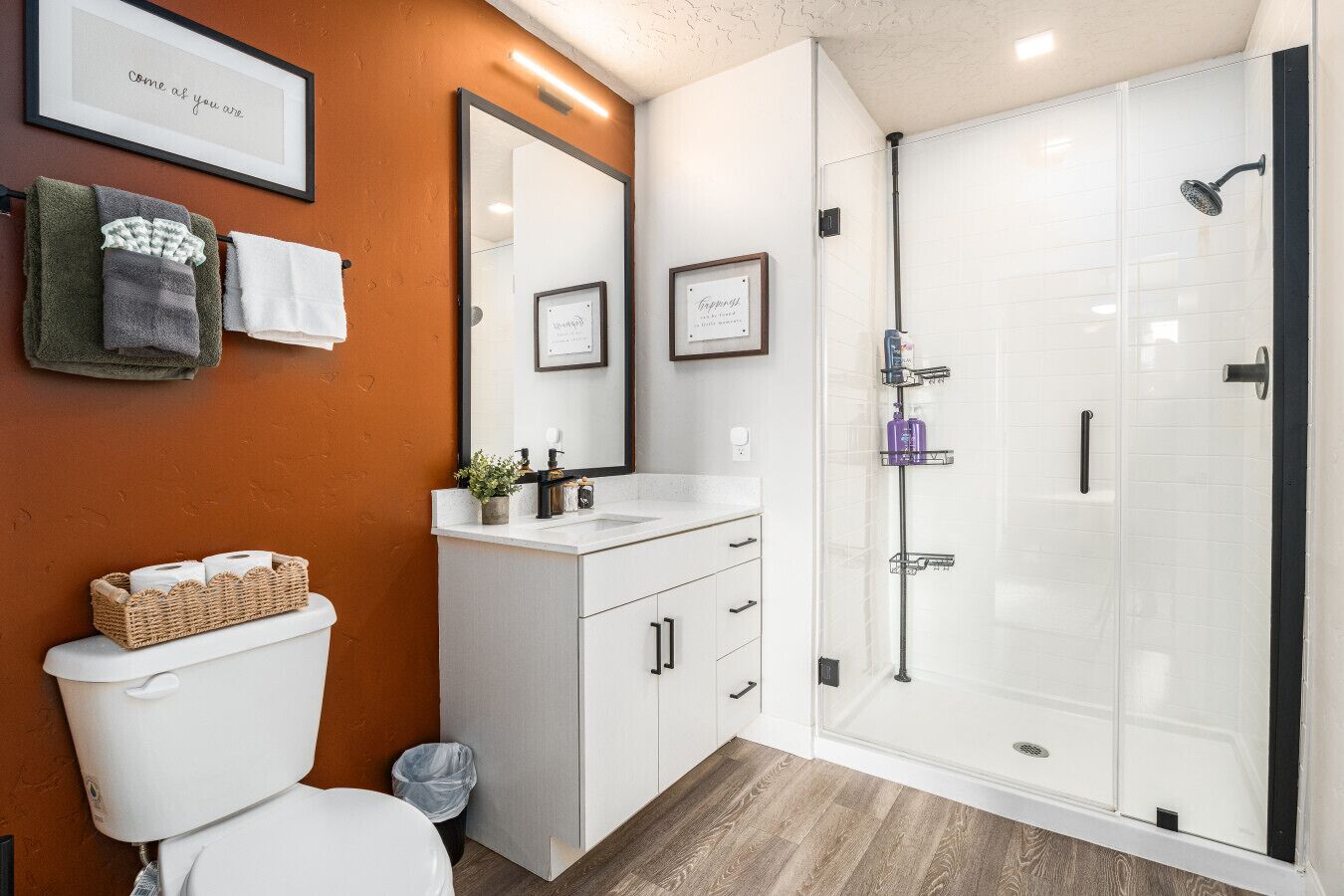 Un baño moderno con inodoro, lavamanos y ducha.