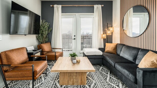 Een moderne woonkamer met een bank, fauteuil en salontafel.