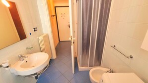 A bathroom with a sink, bidet, and shower area. - Blue Bilo with terrace facing the sea and beach (Marcelli)