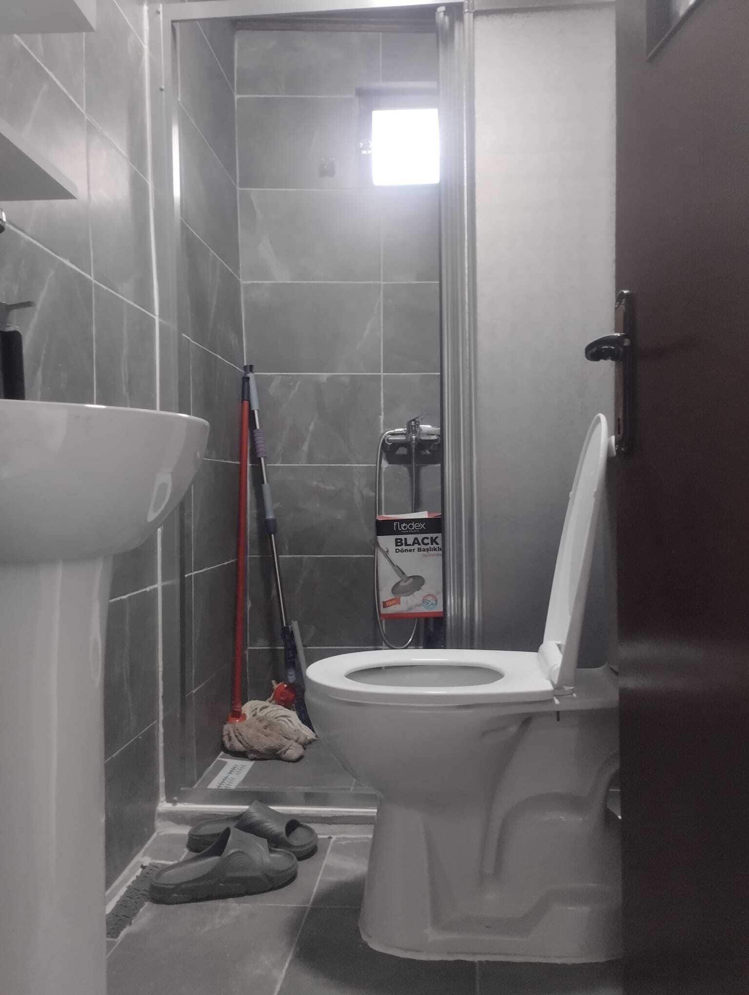 Une salle de bain comprenant des toilettes, un lavabo et un espace douche.