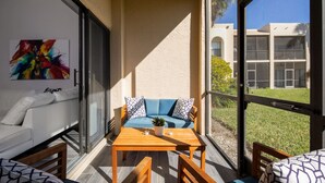 Ein Balkon mit einer Couch, einem Tisch und Stühlen.