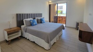 Ein Schlafzimmer mit Bett, Nachttisch, Schreibtisch und Deckenventilator.