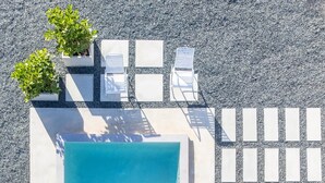 A square pool with clear water, surrounded by white lounge chairs and potted plants. - My Sandlot Parguera- Beach Chalet up to 16 guests (La Parguera)