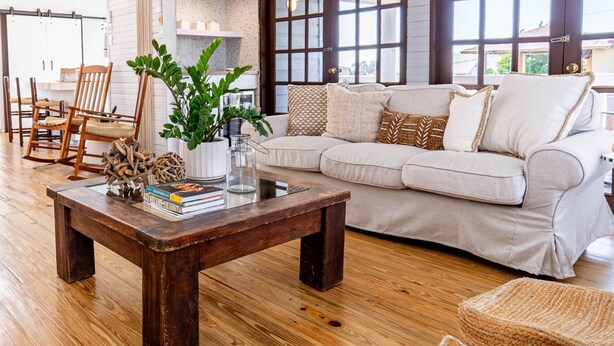 A spacious living room with a wooden coffee table, a white sofa, and a ceiling fan. - My Sandlot Parguera- Beach Chalet up to 16 guests (La Parguera)