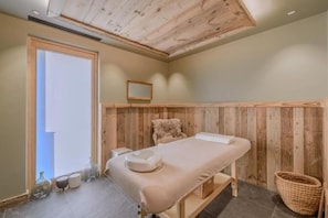 A room with a wooden ceiling, a bed with a white mattress and pillow, a small chair, and a basket. - L'eclat D Veriaz Piscine Jacuzzi Megève (Megève)