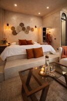 Un dormitorio moderno con una cama grande, una mesita de cristal con velas y vistas al baño.