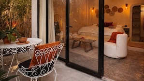 A modern outdoor seating area with a glass door leading to a living room. - The Hidden Garden (San Marcos La Laguna)