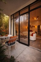 Un área de estar moderna al aire libre con un ventanal de vidrio que da a una sala.