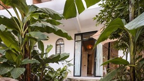 A garden pathway with circular stone steps surrounded by large rocks and tropical plants. - The Hidden Garden (San Marcos La Laguna)