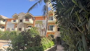 Un hotel con varios balcones, fachada de piedra y un mural.