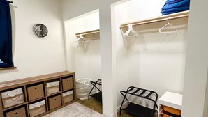Ein Zimmer mit Schrank, einer Bank und Aufbewahrungsboxen.