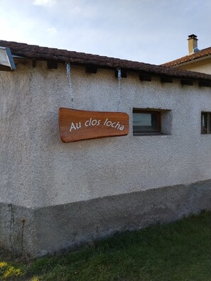Un edificio rústico con un letrero de madera que dice