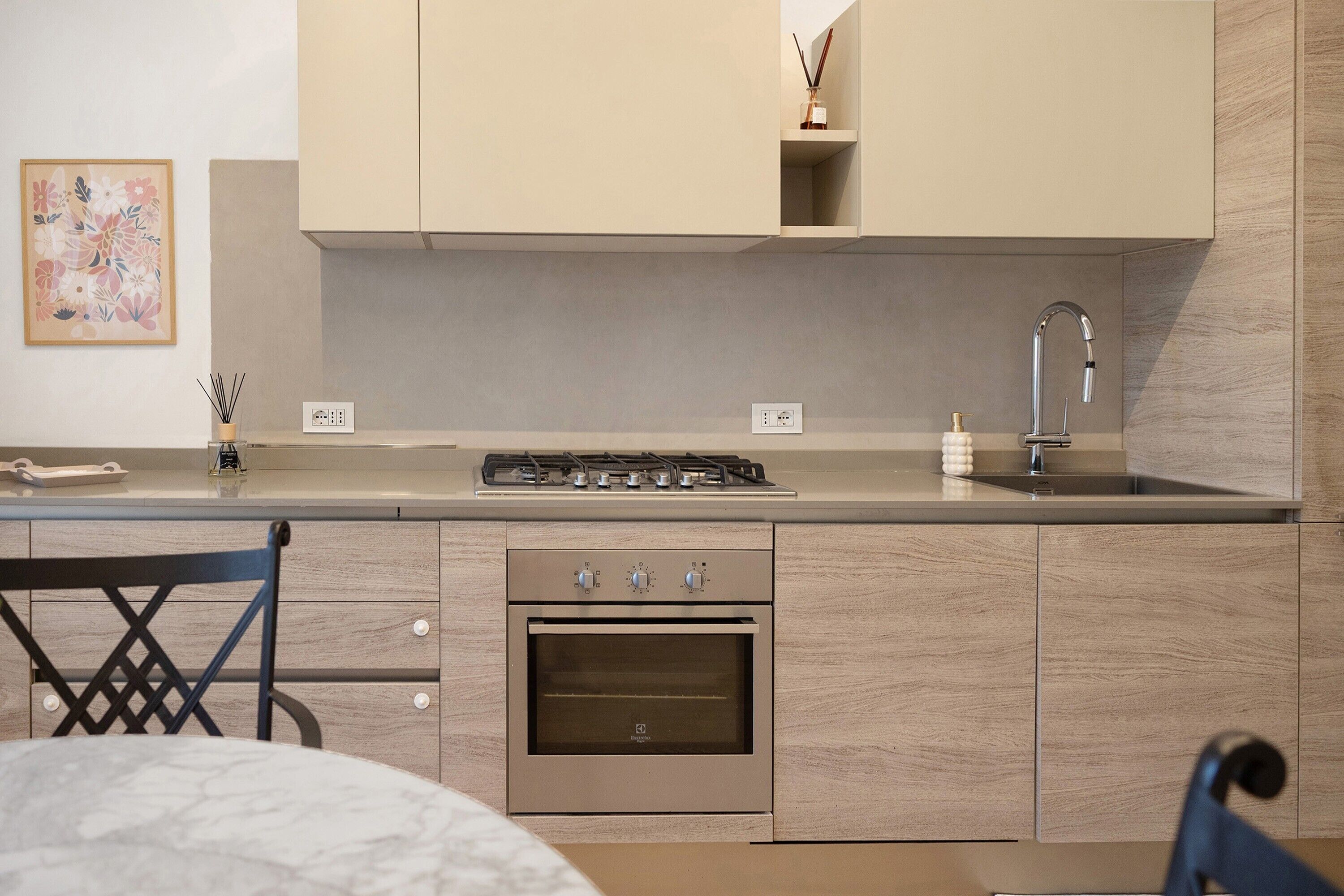 A modern kitchen with a built-in oven, a gas stove, and a sink.