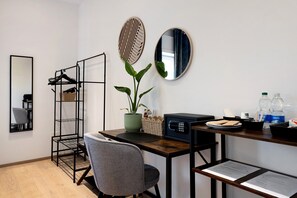 A modern room with a wooden desk, a chair, a potted plant, a microwave, and a hanging plant. - Suite Arena with Spacious Private Terrace (Verona)