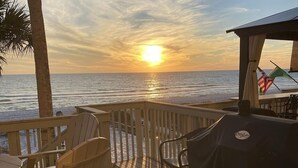 A wooden deck with chairs and a grill, overlooking the ocean at sunset. - Gulfs Edge Townhome #16 - Sealee (Panama City Beach)