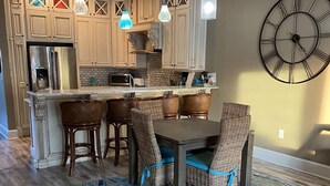 A modern kitchen with wooden cabinets, a built-in island, and pendant lighting. - Gulfs Edge Townhome #16 - Sealee (Panama City Beach)