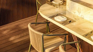 An outdoor dining area with a view of a cityscape and a river. - TUI BLUE Han River (Da Nang)