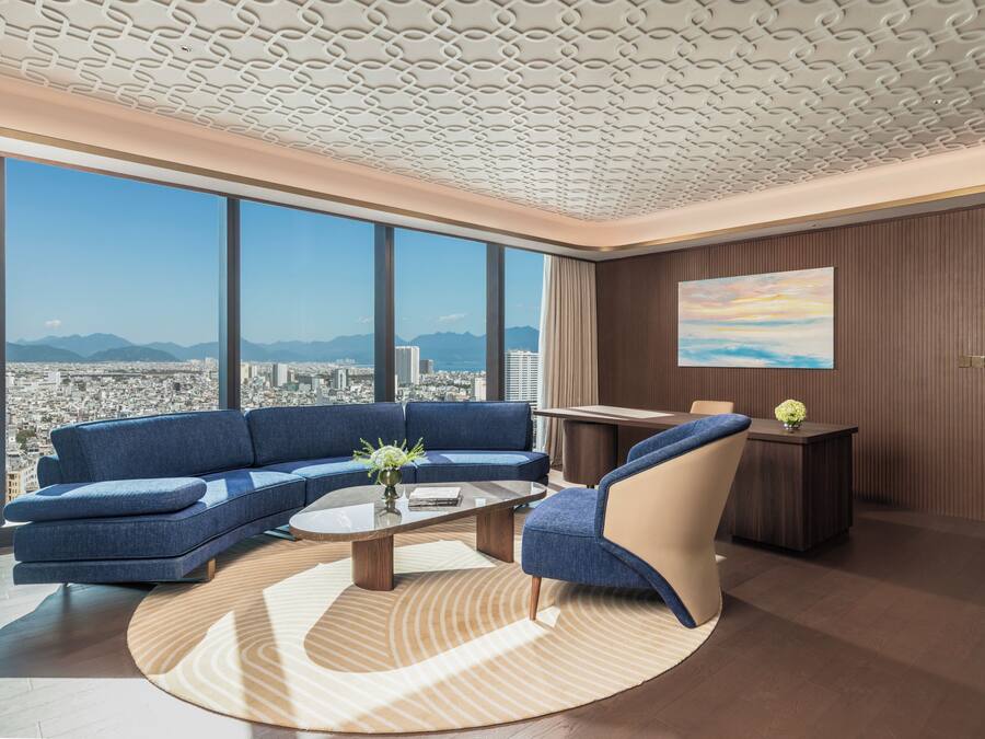 A modern living room with a city view, a sofa, a coffee table, and a chair.