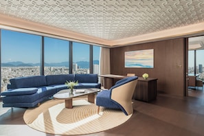 A modern living room with a city view, a sofa, a coffee table, and a chair. - TUI BLUE Han River (Da Nang)