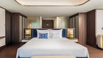 Een hotelkamer met een groot bed, twee nachtkastjes, een hoofdeinde en een plafondlamp.