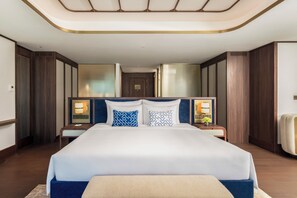 A hotel room with a large bed, two bedside tables, a nightstand, a headboard, and a ceiling light fixture. - TUI BLUE Han River (Da Nang)