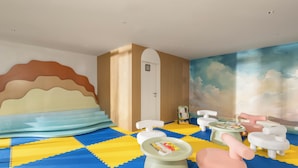 A children's play area with foam mats, a small table with toys, and a wall mural. - TUI BLUE Han River (Da Nang)